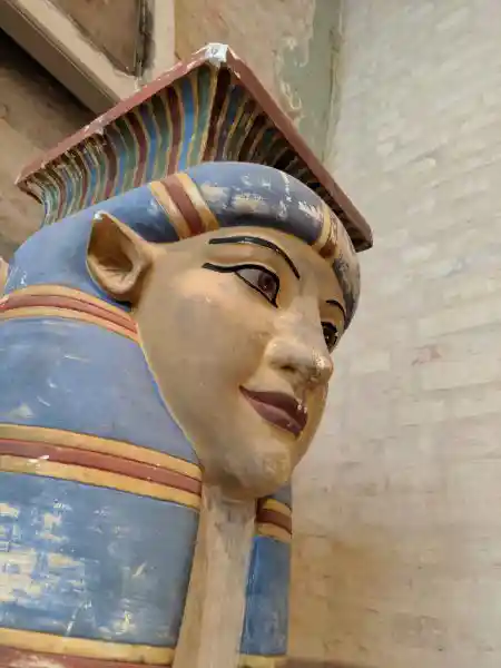 Painted Egyptian column capital depicting the face and headdress of a goddess Hathor